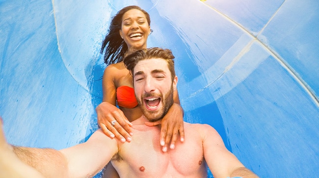 a couple sliding down a water park slide