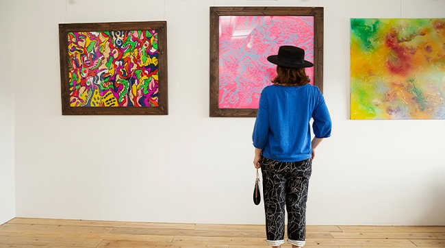 a woman looking at art in an art gallery