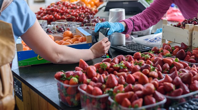 a woman paying at a farmers market