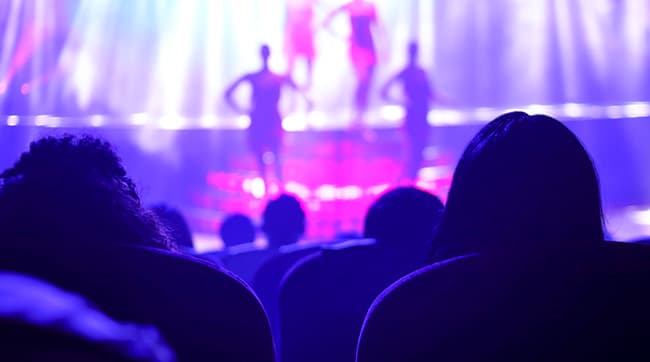 people sat in a theatre watching a performance in Guildford, Surrey